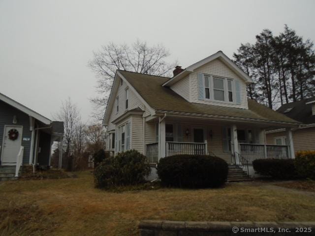 view of front of property featuring covered porch and a front lawn