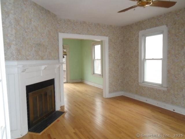 unfurnished living room featuring light hardwood / wood-style floors and ceiling fan