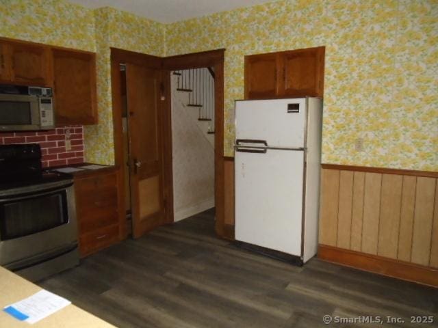 kitchen featuring stainless steel range with electric stovetop, dark hardwood / wood-style floors, and white fridge