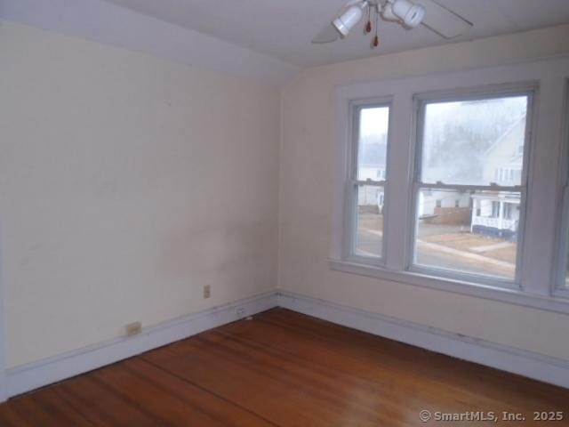 spare room with hardwood / wood-style floors, vaulted ceiling, and ceiling fan