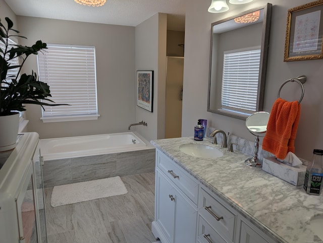 bathroom featuring vanity and shower with separate bathtub