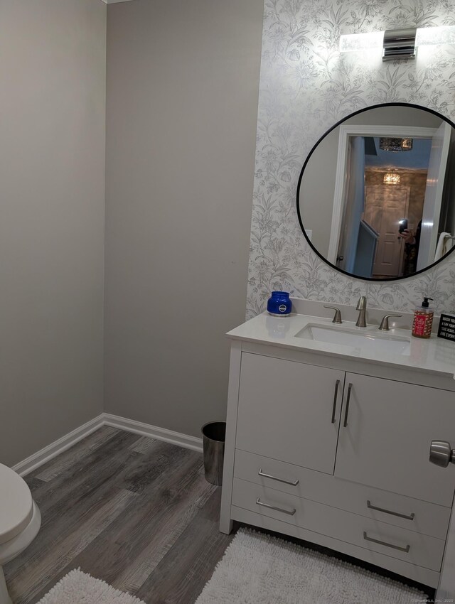 bathroom featuring vanity, hardwood / wood-style floors, and toilet