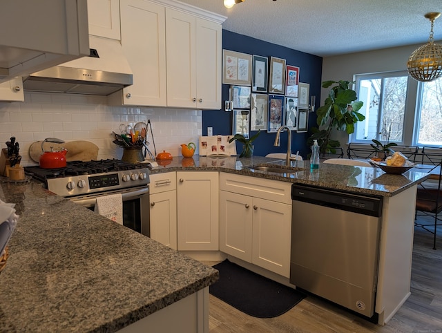 kitchen with sink, white cabinetry, light wood-type flooring, kitchen peninsula, and stainless steel appliances