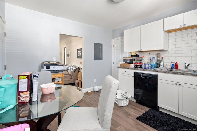 kitchen with sink, white cabinetry, black dishwasher, and light wood-type flooring