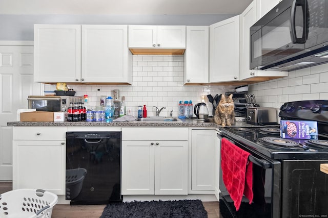 kitchen featuring decorative backsplash, sink, white cabinets, and black appliances