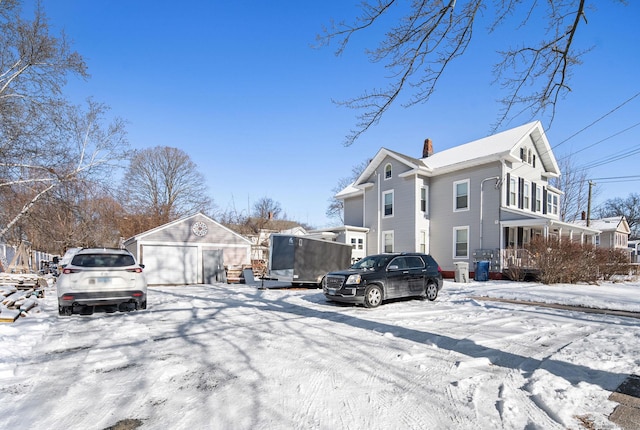 view of front of home with a garage and an outbuilding