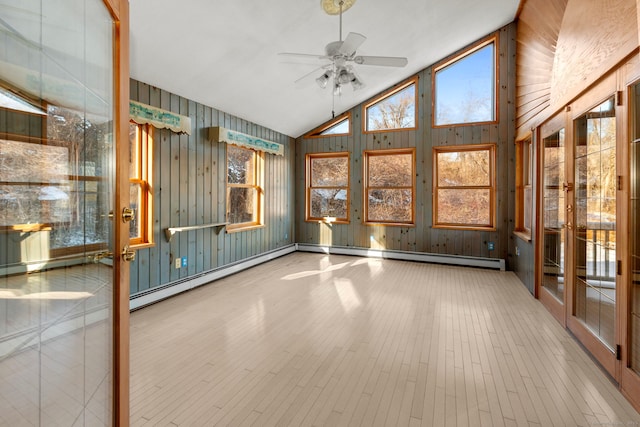 unfurnished sunroom featuring a wealth of natural light, vaulted ceiling, a baseboard radiator, and ceiling fan