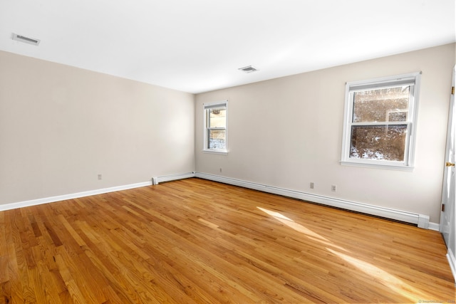 empty room featuring light hardwood / wood-style flooring and a baseboard heating unit