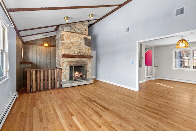 unfurnished living room with a fireplace, wooden walls, a baseboard radiator, wood-type flooring, and beam ceiling