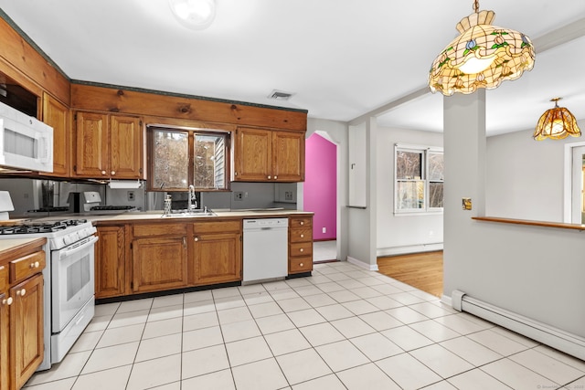 kitchen featuring baseboard heating, white appliances, decorative light fixtures, and sink