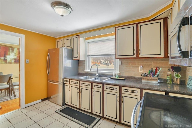 kitchen with light tile patterned flooring, appliances with stainless steel finishes, sink, and backsplash