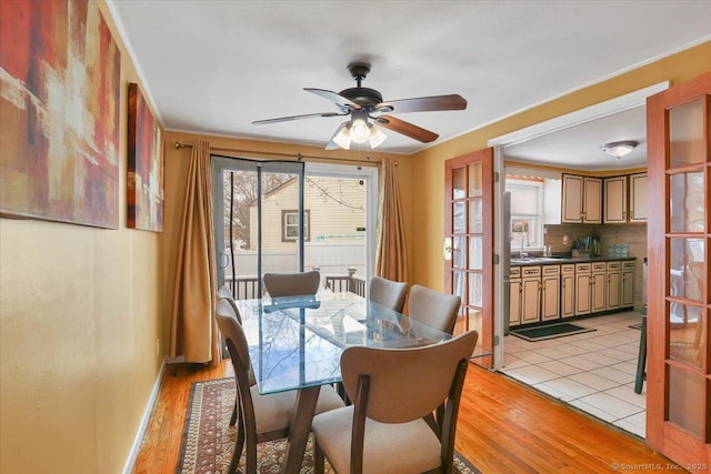 dining space with ceiling fan, sink, and light hardwood / wood-style flooring