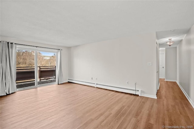 empty room with a baseboard radiator and light hardwood / wood-style floors