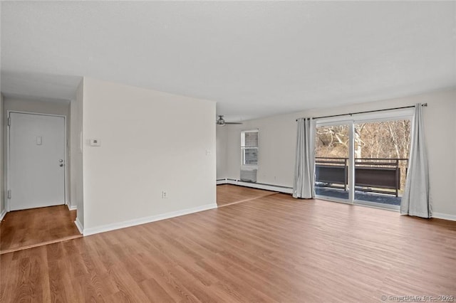 unfurnished room with baseboard heating, ceiling fan, and light hardwood / wood-style floors