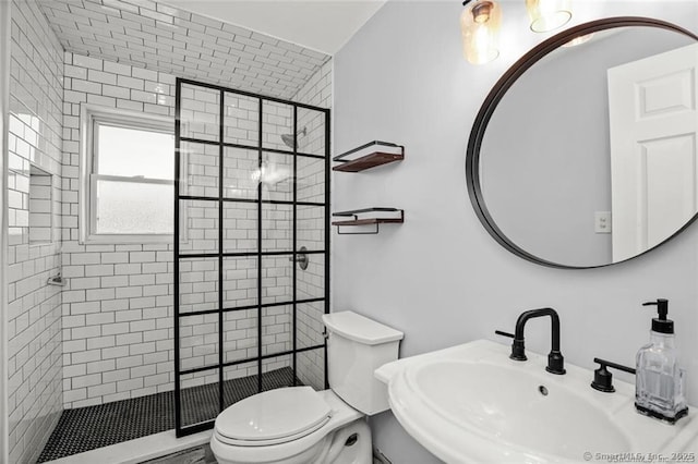 bathroom featuring sink, toilet, and tiled shower