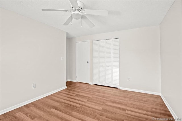 unfurnished bedroom with ceiling fan, a closet, and light wood-type flooring