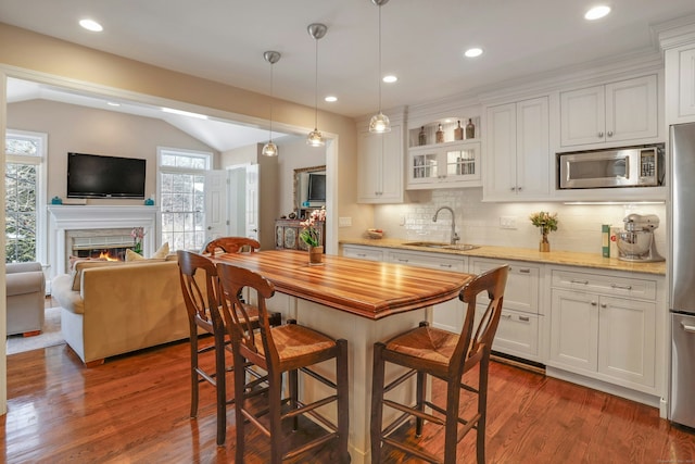 kitchen with white cabinetry, sink, vaulted ceiling, and appliances with stainless steel finishes