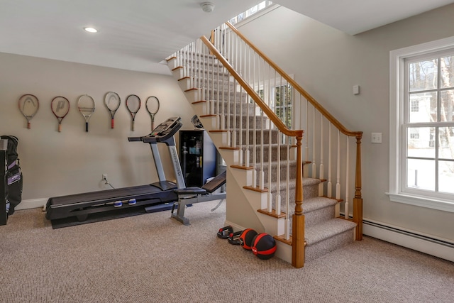 exercise area with plenty of natural light, baseboard heating, and carpet flooring