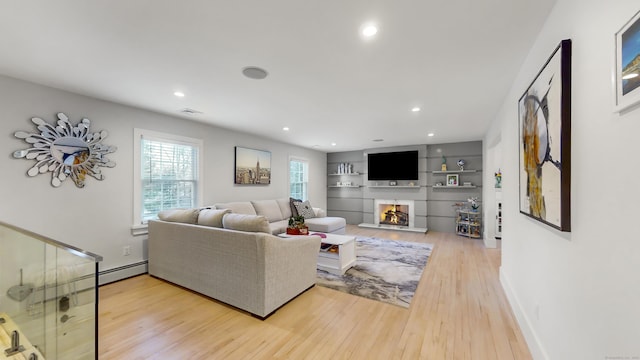 living room with built in shelves and light wood-type flooring