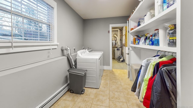 laundry area featuring light tile patterned floors, plenty of natural light, washing machine and clothes dryer, and a baseboard heating unit