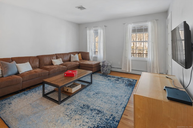 living room featuring baseboard heating and light wood-type flooring