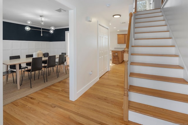 stairs with hardwood / wood-style flooring and crown molding