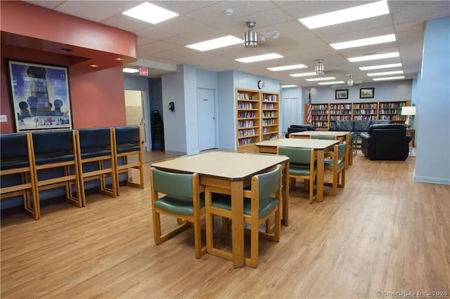 interior space with a paneled ceiling and light hardwood / wood-style floors