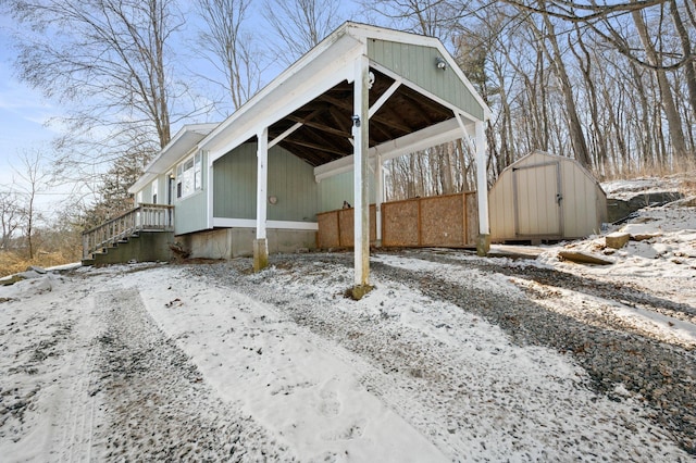 snow covered property with a storage shed