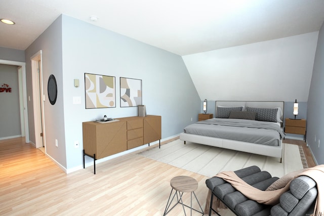 bedroom featuring light wood-type flooring, lofted ceiling, baseboards, and recessed lighting