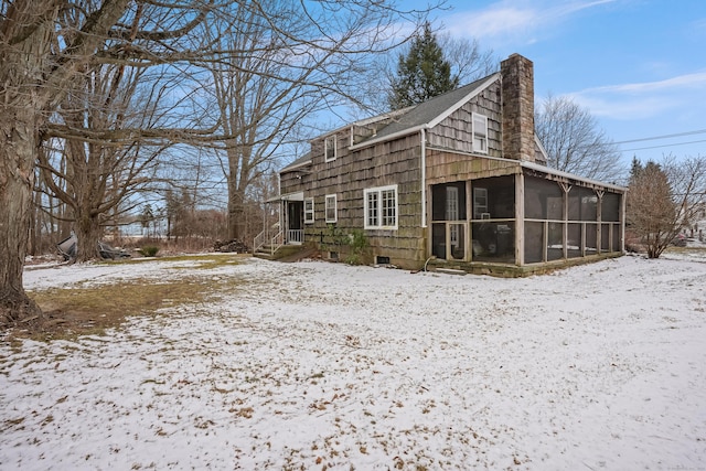 view of snow covered exterior featuring a sunroom