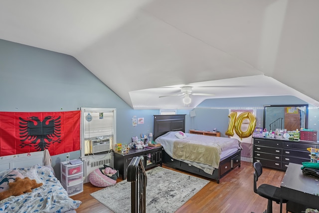 bedroom featuring vaulted ceiling, ceiling fan, hardwood / wood-style flooring, radiator, and cooling unit