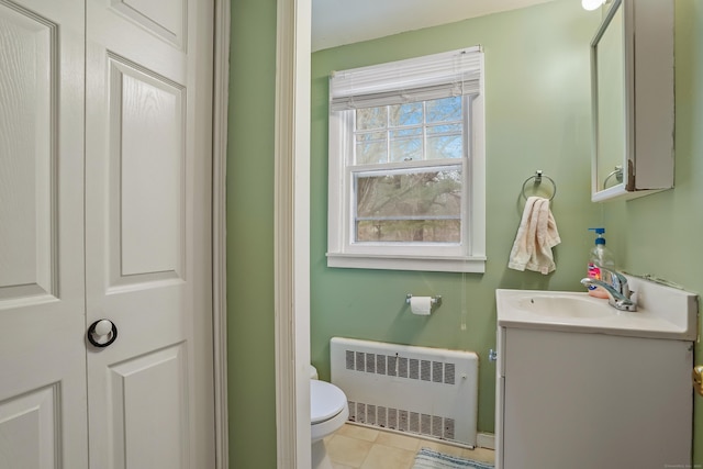 bathroom with toilet, radiator, tile patterned flooring, and vanity