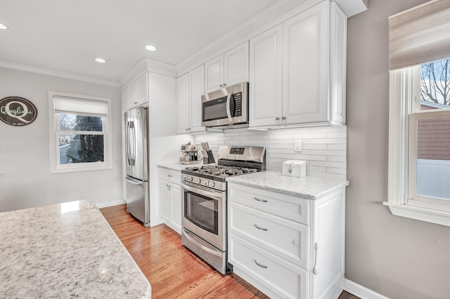63 Contact Dr, West Haven, CT 06516 - kitchen featuring white cabinets, crown molding, light wood finished floors, stainless steel appliances, and backsplash