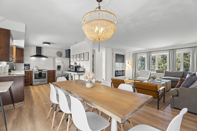 dining room featuring an inviting chandelier, sink, and light hardwood / wood-style floors