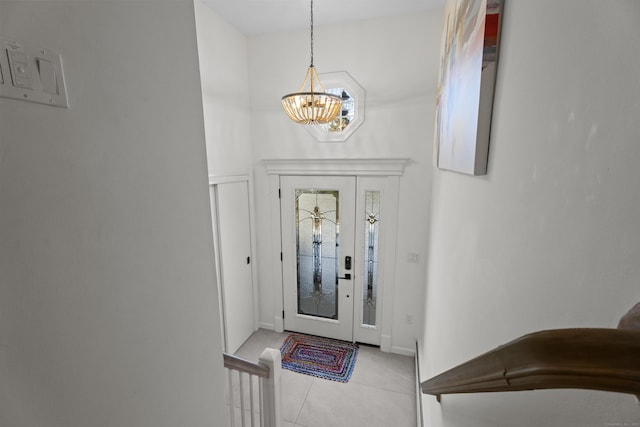 tiled entryway with a chandelier