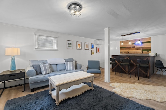 living room featuring crown molding, bar area, light hardwood / wood-style flooring, and an AC wall unit