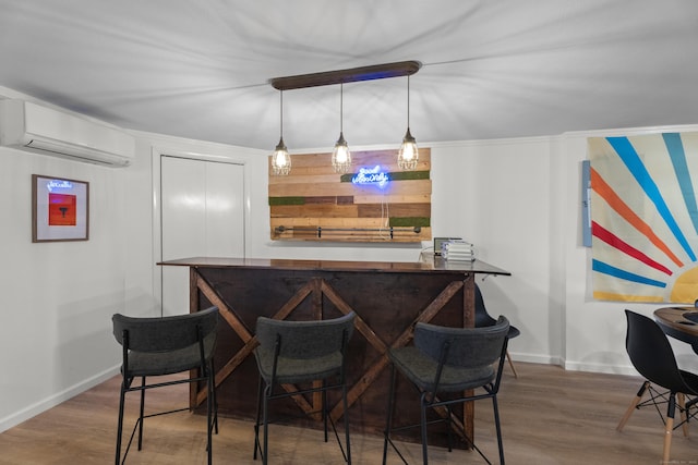 bar featuring crown molding, pendant lighting, dark wood-type flooring, and a wall mounted air conditioner