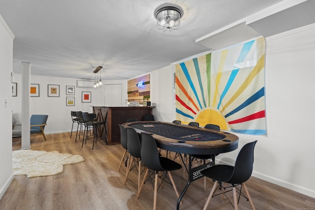 dining room featuring wood-type flooring, indoor bar, and crown molding