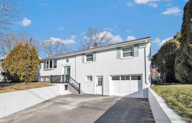 bi-level home featuring a garage and a front yard