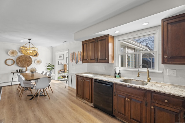 kitchen featuring sink, crown molding, hanging light fixtures, black dishwasher, and light hardwood / wood-style floors