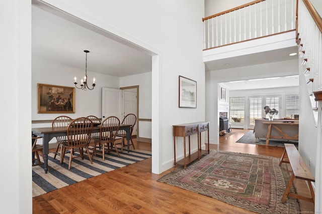 entryway featuring a notable chandelier, a fireplace, baseboards, and wood finished floors