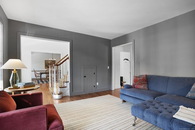 living area with a chandelier, baseboards, and wood finished floors