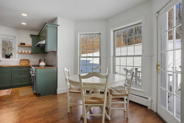 dining area with a baseboard heating unit, recessed lighting, wainscoting, and wood finished floors