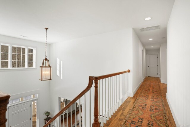 corridor with recessed lighting, an upstairs landing, baseboards, light wood-style floors, and visible vents