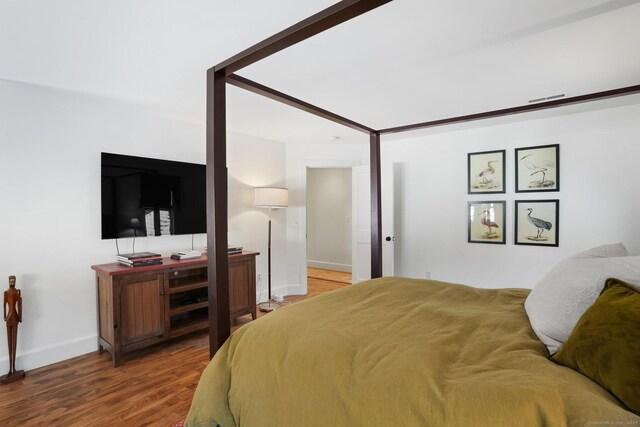 bedroom featuring wood finished floors and baseboards