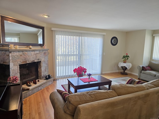 living room with a fireplace and light wood-type flooring