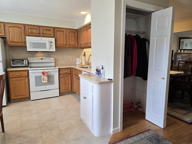 kitchen featuring tasteful backsplash, sink, and white appliances