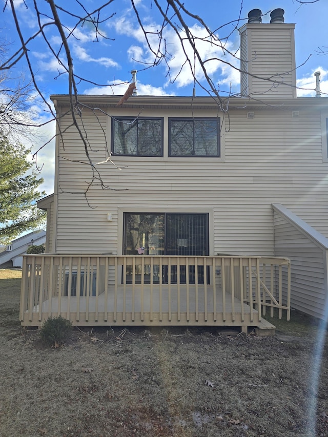 rear view of property featuring a wooden deck