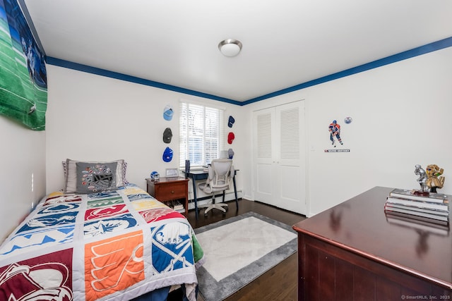 bedroom with ornamental molding, dark hardwood / wood-style floors, a closet, and a baseboard heating unit