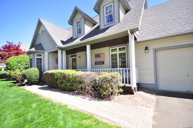 view of front of property with roof with shingles, covered porch, and a front lawn